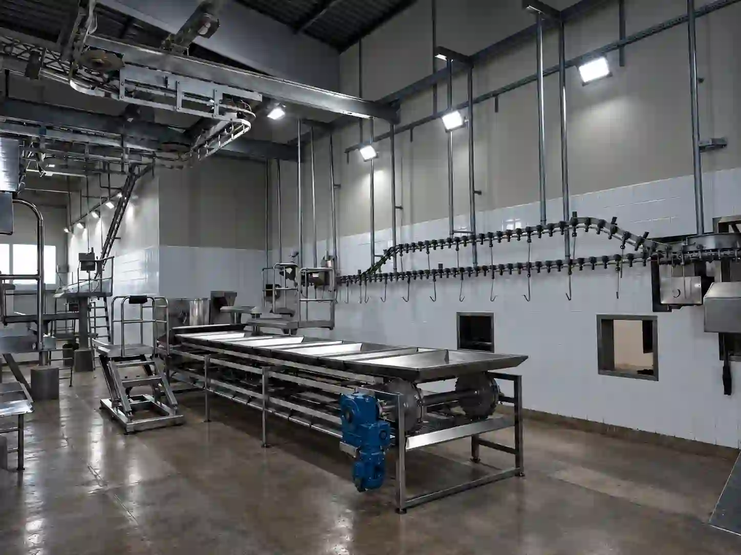 Linha de trilhagem aérea em aço inox com motorredutor, ambiente frigorífico revestido de azulejo, fabricação Frigomat